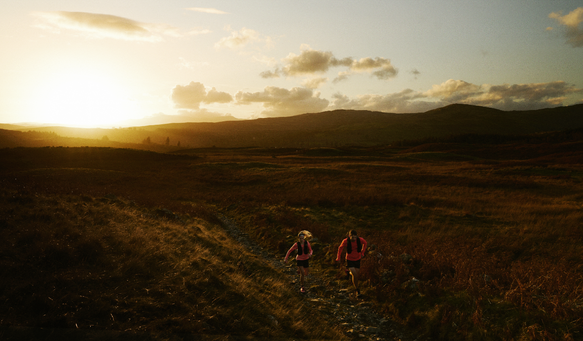 runners on a trail at sunrise