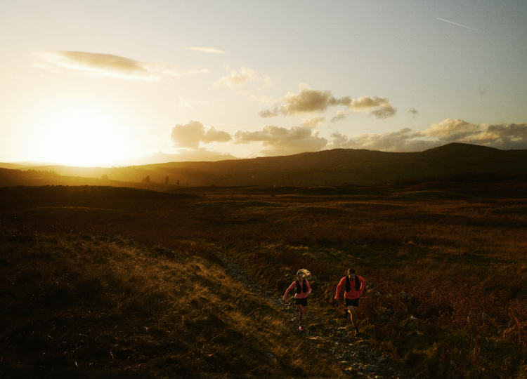 runners on a trail at sunrise